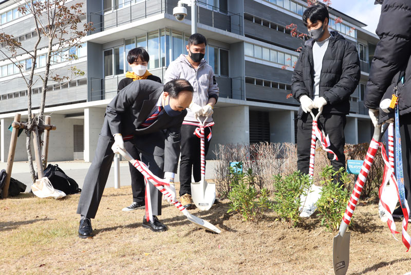 苗に土をかけている学長