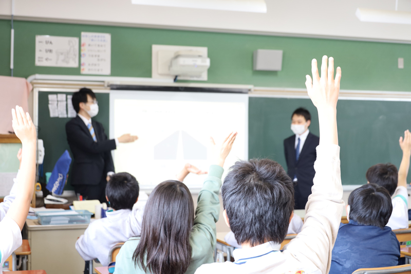 手を上げる小学生たち