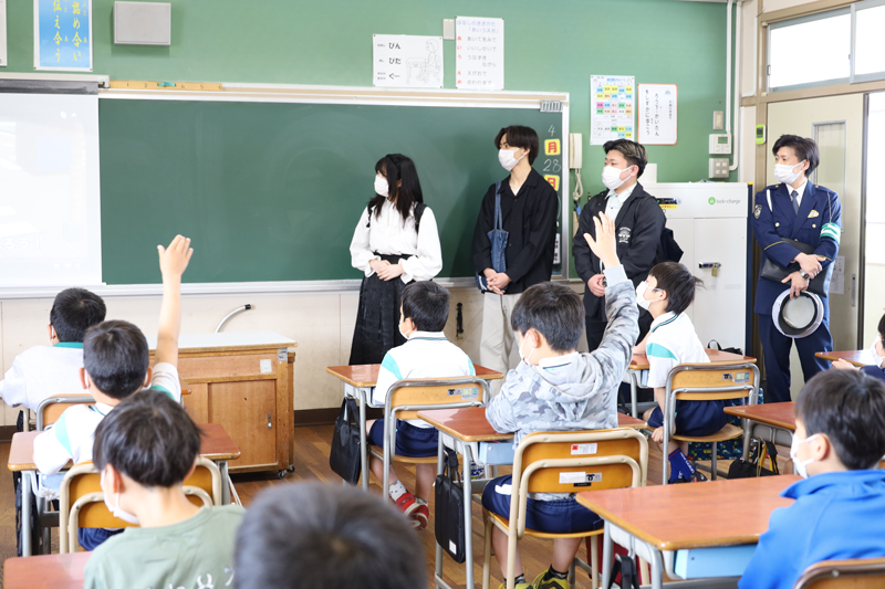 小学生の前に立つ大学生たち