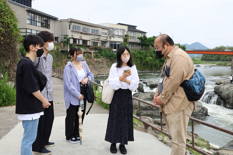 地元の方から闘竜灘の説明を受ける学生たち