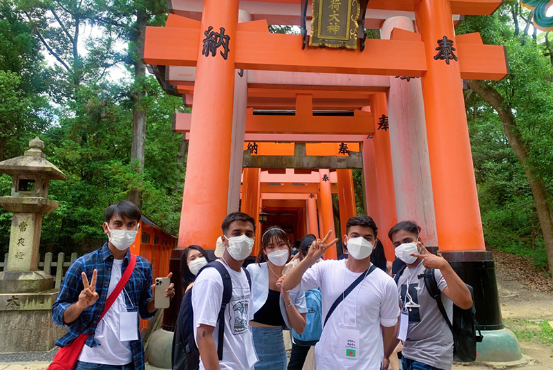 鳥居前で撮影する学生たち