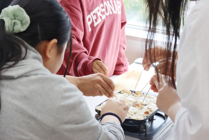 たこ焼きを作る学生たち