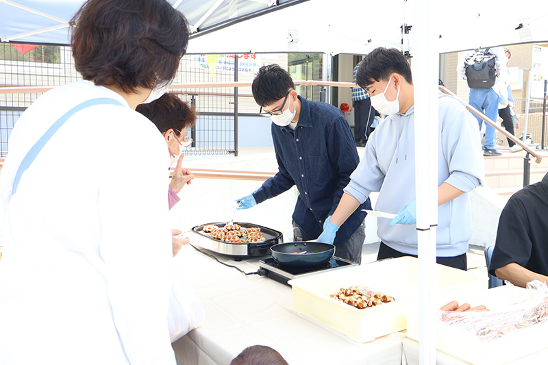 ワッフルとフランクフルトを焼くゼミ生たち