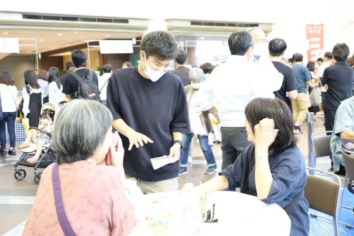 チラシを配りながら説明するゼミ生